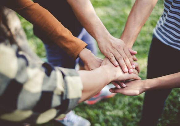 Stacking hands of young teen student, teamwork, togetherness and cooperation concept